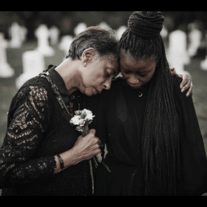 grieving family of a truck accident victim consoling each other at the cemetery